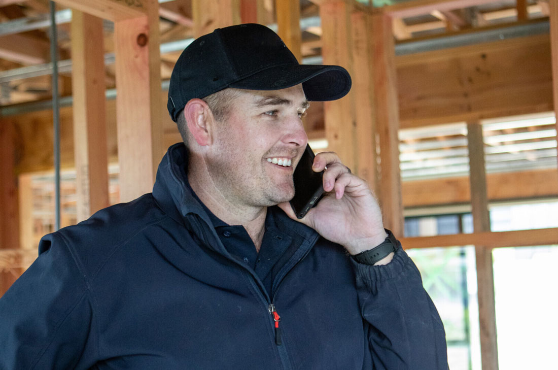 smiling-builder-on-phone-to-supplier